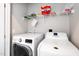 Bright laundry room featuring white washer, dryer, and wire shelving at 10530 Sablewood Dr # 112, Raleigh, NC 27617