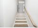 Wooden staircase leading to front door in a neutral hallway at 10530 Sablewood Dr # 112, Raleigh, NC 27617