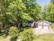 Aerial view of a home with mature trees, detached garage and driveway at 107 Forest Rd, Oxford, NC 27565