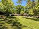 Expansive backyard with lush lawn, mature trees, and outdoor seating areas perfect for relaxing and entertaining at 107 Forest Rd, Oxford, NC 27565