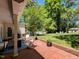 A brick patio with a fire pit, seating, and a large backyard surrounded by mature trees and greenery at 107 Forest Rd, Oxford, NC 27565