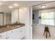 Bright bathroom with white cabinetry, granite countertop, tiled floors and a window view at 107 Forest Rd, Oxford, NC 27565