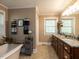 Bathroom featuring a soaking tub, double vanity with granite countertop, and natural lighting at 107 Forest Rd, Oxford, NC 27565