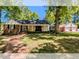 Charming home featuring a welcoming front porch and a detached two-car garage, surrounded by lush trees at 107 Forest Rd, Oxford, NC 27565