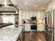 View of the kitchen featuring stainless steel appliances and granite countertops, seamlessly connecting to the living area at 107 Forest Rd, Oxford, NC 27565