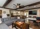 Spacious living room flowing into the kitchen and featuring hardwood floors, wooden beams, and a large gray sofa at 107 Forest Rd, Oxford, NC 27565