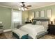 Well-lit primary bedroom with a ceiling fan, carpet and stylish decor at 107 Forest Rd, Oxford, NC 27565