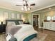 Primary bedroom featuring windows, decorative accents, a bench, and an ensuite bathroom at 107 Forest Rd, Oxford, NC 27565