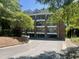 Three-story condo building with brick accents and balconies, surrounded by mature trees at 113 Conner Dr # 103, Chapel Hill, NC 27514
