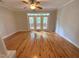 Bright living room with hardwood floors and access to outdoor balcony via glass doors at 113 Conner Dr # 103, Chapel Hill, NC 27514