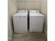A laundry area with both washer and dryer units, with shelving above for storage solutions at 113 Conner Dv # 106, Chapel Hill, NC 27514