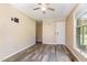 A simple bedroom with hardwood floors, neutral walls, and a ceiling fan at 1303 Cherry Dr, Burlington, NC 27215