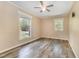 Sunlit bedroom with hardwood floors, neutral walls, and a ceiling fan at 1303 Cherry Dr, Burlington, NC 27215