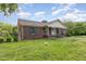 Beautiful brick home featuring classic shutters, a welcoming porch, and landscaped front yard at 1303 Cherry Dr, Burlington, NC 27215