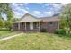 Beautiful brick home featuring classic shutters, a welcoming porch, and landscaped front yard at 1303 Cherry Dr, Burlington, NC 27215