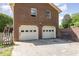 This image shows the back of the house with two garages and a wooden deck at 1303 Cherry Dr, Burlington, NC 27215