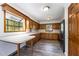 Functional kitchen with wood cabinets, laminate countertops, and a sunny window overlooking the yard at 1303 Cherry Dr, Burlington, NC 27215