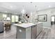 Bright kitchen with island featuring a stainless dishwasher, sink, seating, and open floor plan at 137 Cultivator Ct, Angier, NC 27501