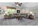Spacious living room featuring a large sectional sofa, ceiling fan, and window with natural light at 137 Cultivator Ct, Angier, NC 27501
