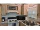 This kitchen includes a microwave, range, and double sink with wood cabinets and decor at 1605 Sagamore Dr, Louisburg, NC 27549