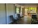 This is a screened porch with a seating area and view of nature at 1605 Sagamore Dr, Louisburg, NC 27549