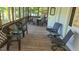 Relaxing screened-in porch with wood flooring and comfortable seating and table for outdoor dining at 1605 Sagamore Dr, Louisburg, NC 27549