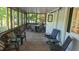 Relaxing screened-in porch with wood flooring and comfortable seating and table for outdoor dining at 1605 Sagamore Dr, Louisburg, NC 27549