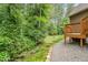 Landscaped backyard featuring lush greenery, stone accents, and a charming patio area at 1619 Carriage Dr, Franklinton, NC 27525