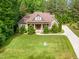 Well-kept home surrounded by mature trees and landscaping, long driveway and large lawn at 1619 Carriage Dr, Franklinton, NC 27525