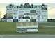 A business advertisement billboard for Home of The Trojans with various businesses listed at 169 Pecan Valley Way, Four Oaks, NC 27524