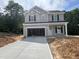 Two-story home with gray siding, black shutters, attached garage, and a long concrete driveway at 169 Pecan Valley Way, Four Oaks, NC 27524