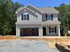 New two-story home features a two-car garage, gray siding, and black shutters, ready for personalization at 169 Pecan Valley Way, Four Oaks, NC 27524