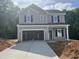New two-story home with attached garage and concrete driveway at 169 Pecan Valley Way, Four Oaks, NC 27524