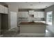 Bright kitchen features white cabinets, a center island, and tile backsplash at 169 Pecan Valley Way, Four Oaks, NC 27524
