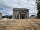 Two-story home featuring gray siding, large windows, and a covered porch ready for your personal touch at 169 Pecan Valley Way, Four Oaks, NC 27524