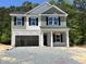 Two-story home with a two-car garage and a covered front porch, still under construction at 183 Pecan Valley Way, Four Oaks, NC 27524