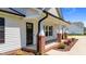 Charming front porch with brick accents, columns, and a black front door at 1914 Jack Rd, Clayton, NC 27520
