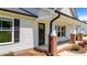 Charming front porch with brick accents, columns, and a black front door at 1914 Jack Rd, Clayton, NC 27520