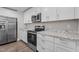 Modern kitchen with stainless steel appliances, granite counters, and ample white cabinets for storage at 1914 Jack Rd, Clayton, NC 27520
