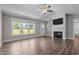 Spacious living room boasting a fireplace, large windows, wood flooring, and a ceiling fan at 1914 Jack Rd, Clayton, NC 27520