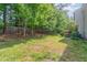 Large backyard with mature trees and a hot tub area behind the house at 203 Downing Bluff Dr, Morrisville, NC 27560