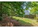 View of the backyard, including a glimpse of the house and wooden fence at 203 Downing Bluff Dr, Morrisville, NC 27560
