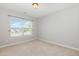 This bedroom has neutral carpet and paint with a window providing a view of the neighborhood at 203 Downing Bluff Dr, Morrisville, NC 27560