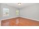 This bedroom has hardwood floors and two windows providing natural light at 203 Downing Bluff Dr, Morrisville, NC 27560