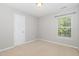 Bedroom featuring neutral carpet and paint with a window providing natural light at 203 Downing Bluff Dr, Morrisville, NC 27560
