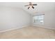 This bedroom has neutral carpet and paint with a window providing a view of the neighborhood at 203 Downing Bluff Dr, Morrisville, NC 27560