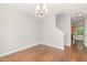 Bright dining room with wood floors, chandelier, and access to kitchen and stairs at 203 Downing Bluff Dr, Morrisville, NC 27560