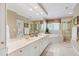 Bright bathroom featuring double sinks, granite countertop, bathtub, and glass enclosed shower at 205 Buncombe St, Raleigh, NC 27609
