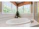 Close up shot of a large bathtub with tiled deck and window with blinds and colorful valance at 205 Buncombe St, Raleigh, NC 27609