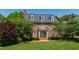 Stately brick home with three dormers, white trim, balcony, and lush green lawn at 205 Buncombe St, Raleigh, NC 27609